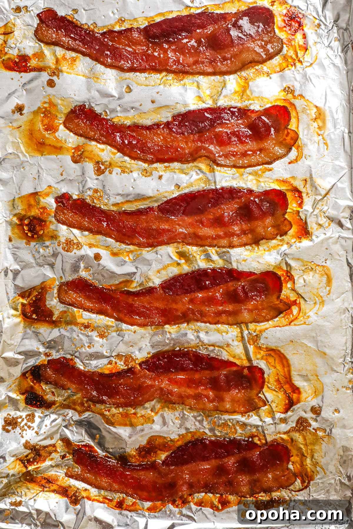 Brown Sugar Glazed Baked Bacon Recipe 2 Oven-baked brown sugar bacon with caramelized edges on a baking sheet.