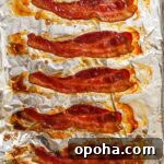 Brown Sugar Glazed Baked Bacon Recipe 9 Oven-baked brown sugar bacon with caramelized edges on a baking sheet.