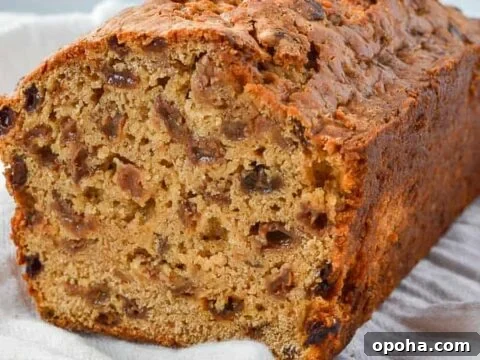 A cut loaf with raisins and sultanas on a white cloth