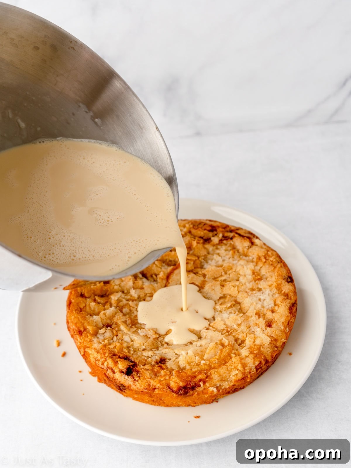 Action shot of three milk mixture being poured onto cake. 