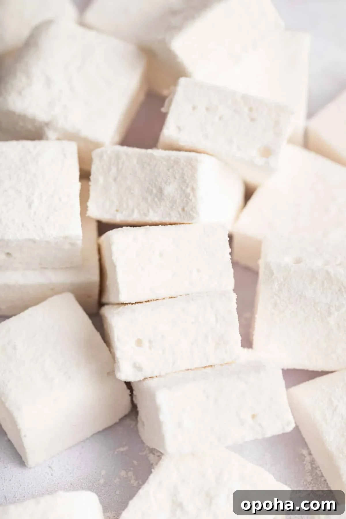 How to Make Homemade Marshmallows from Scratch: Fluffy Recipe 2 Pile of square homemade marshmallows on a white board.