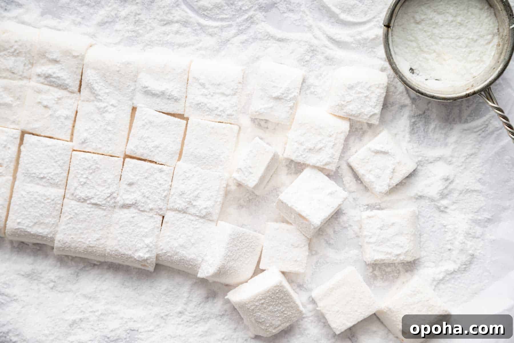 How to Make Homemade Marshmallows from Scratch: Fluffy Recipe 11 Horizontal image of freshly cut homemade marshmallows dusted in powdered sugar.