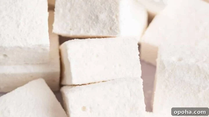 Pile of square homemade marshmallows on a white board.