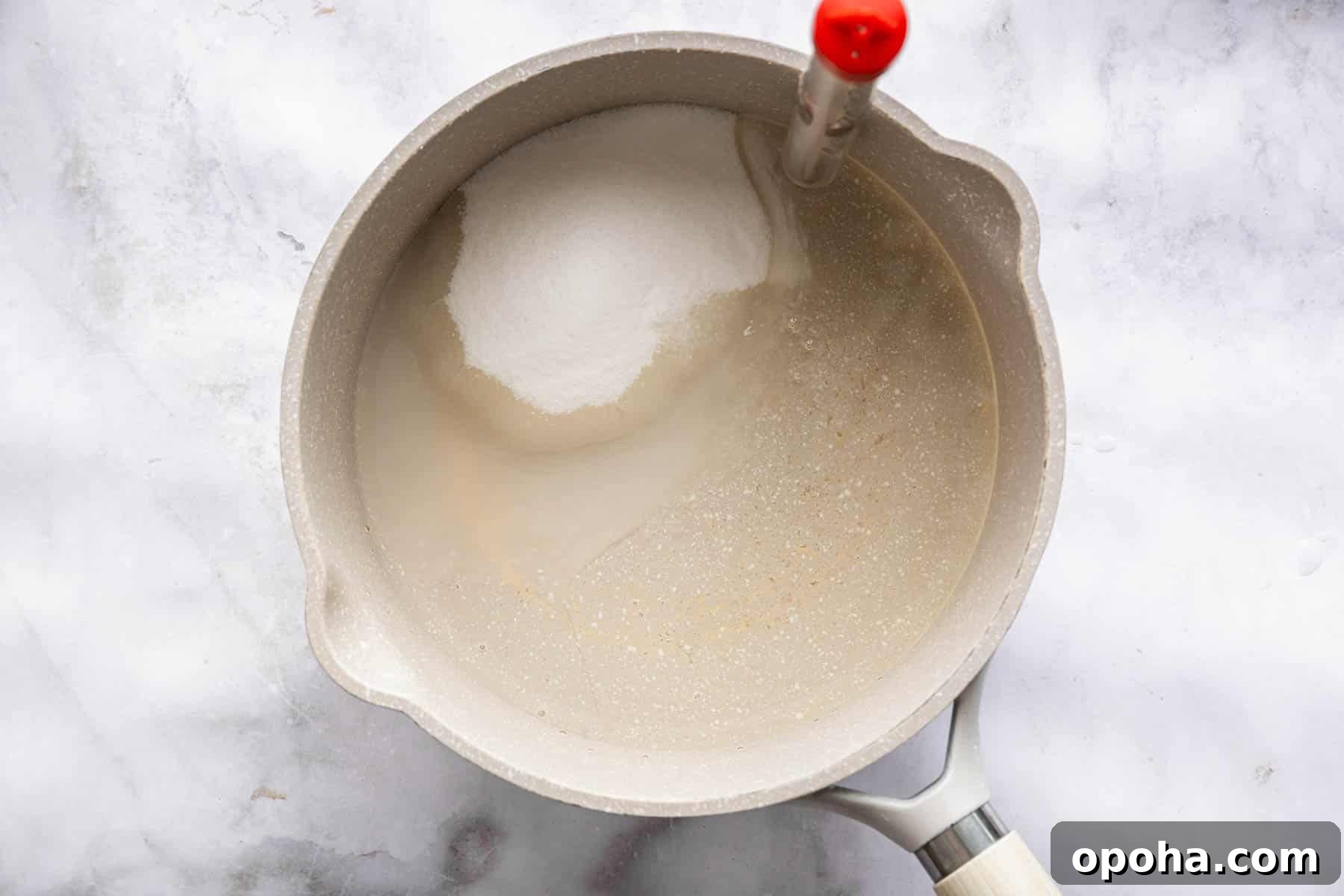 How to Make Homemade Marshmallows from Scratch: Fluffy Recipe 5 Saucepan with sugar, water and red thermometer clipped to the side.