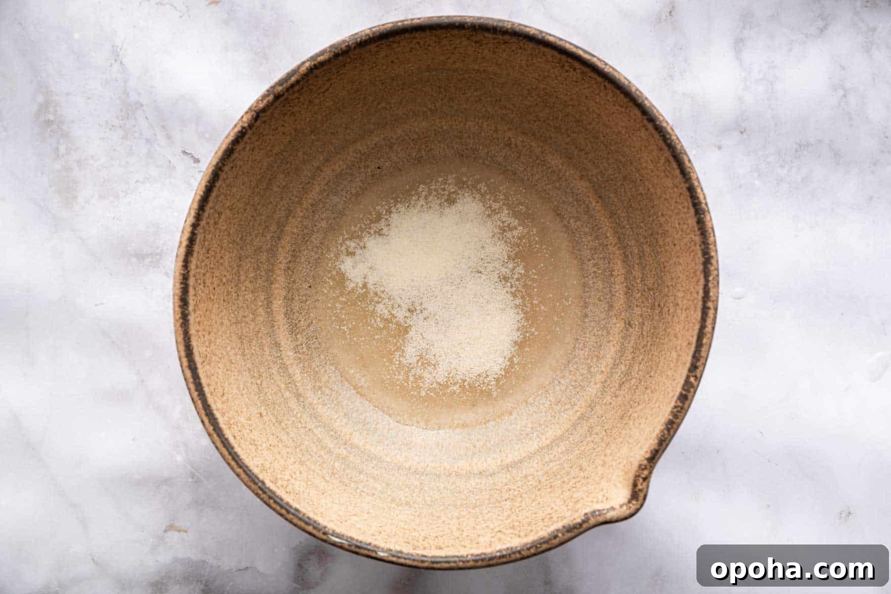 How to Make Homemade Marshmallows from Scratch: Fluffy Recipe 6 Blooming gelatin in cold water in brown bowl.