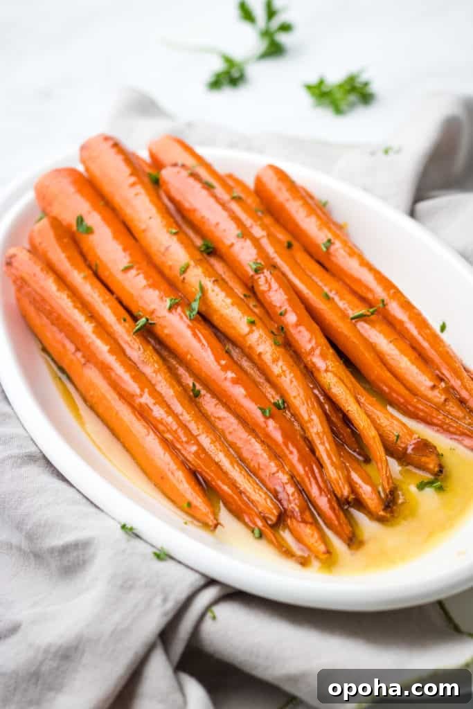 Maple-Glazed Roasted Carrots with Herbs and Balsamic 3 Side view of a white platter holding maple carrots.