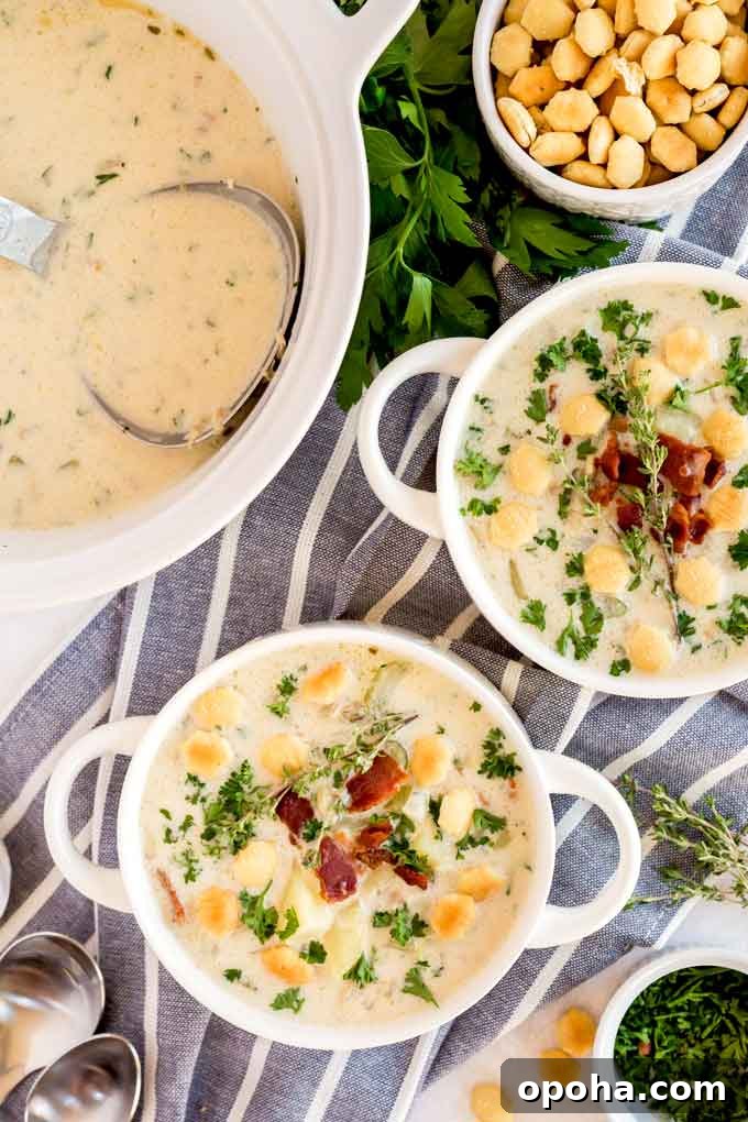 White bowls filled with creamy clam chowder and topped with crispy bacon