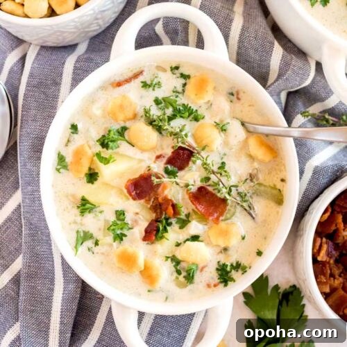 A bowl of creamy clam chowder topped with crispy bacon