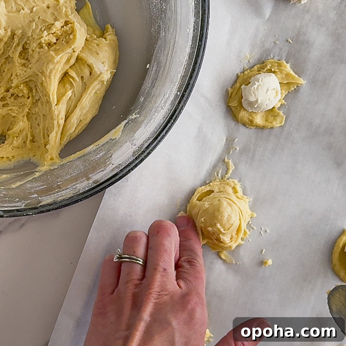 Adding cream cheese to Churro cheesecake cookies.