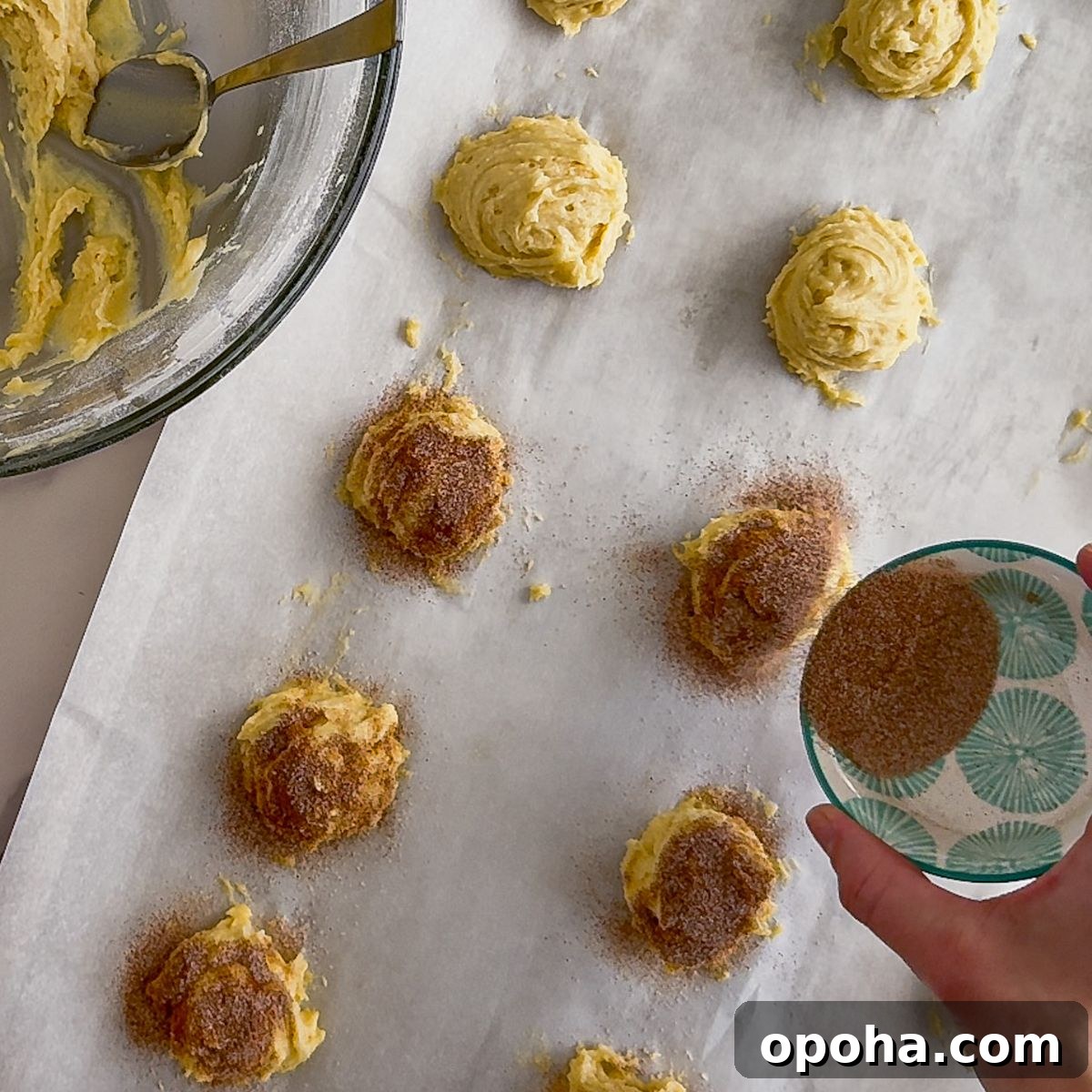 Adding cinnamon to Churro cheesecake cookies.
