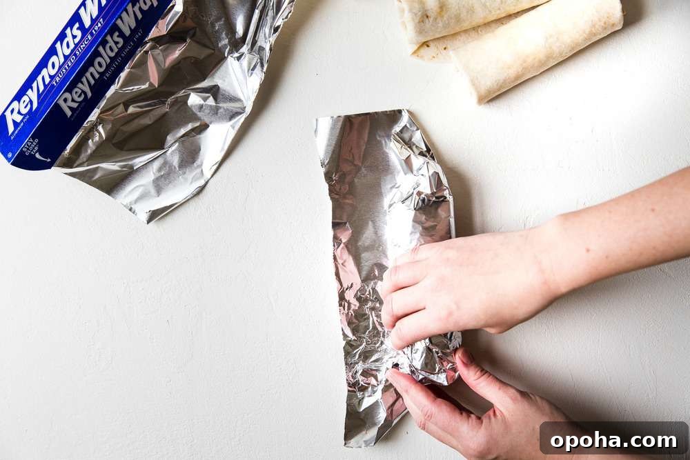 Tuck in the sides of the aluminum foil as you wrap the burrito.