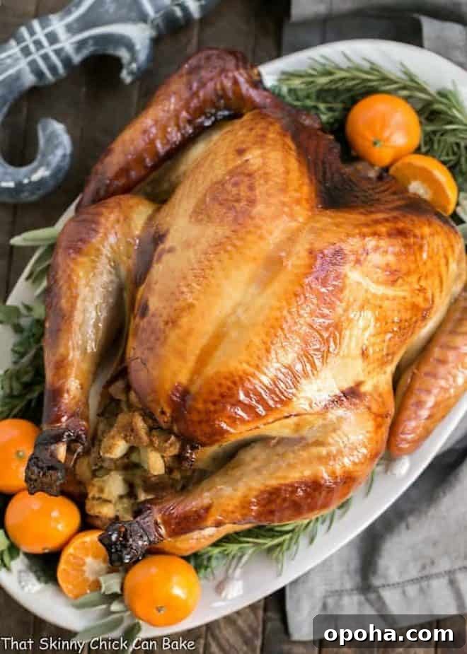 Honey-Brined Holiday Turkey Recipe 2 Honey Brined Turkey on a white platter garnished with herbs and oranges