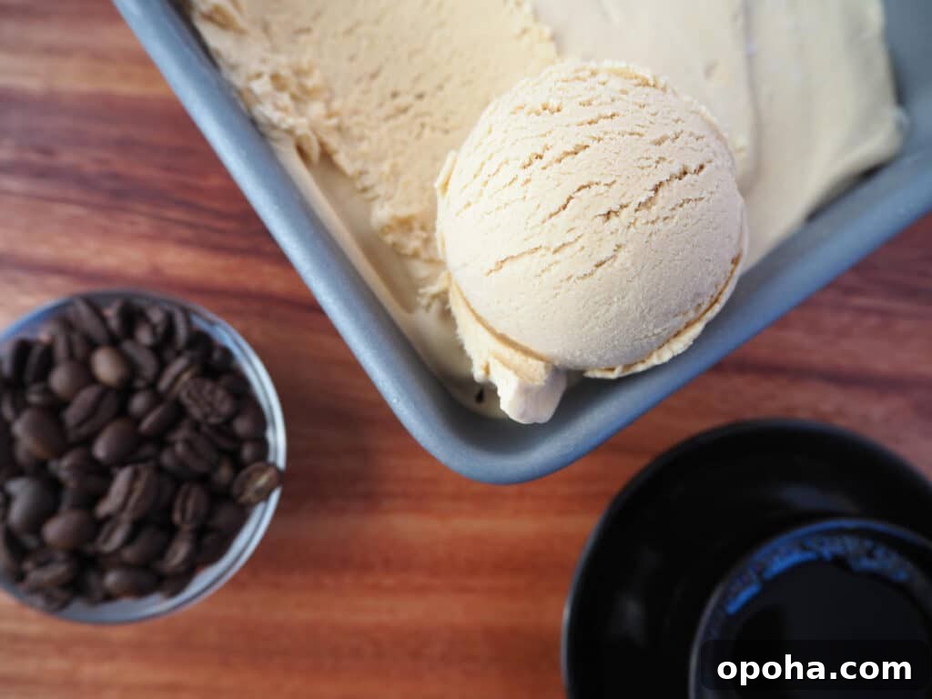 No churn coffee ice cream scoop in pan with bean and coffee
