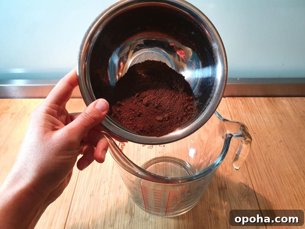 adding ground coffee to jug