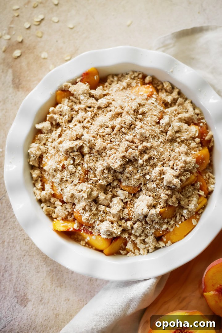 peach crisp with oatmeal in a baking dish before going into the oven