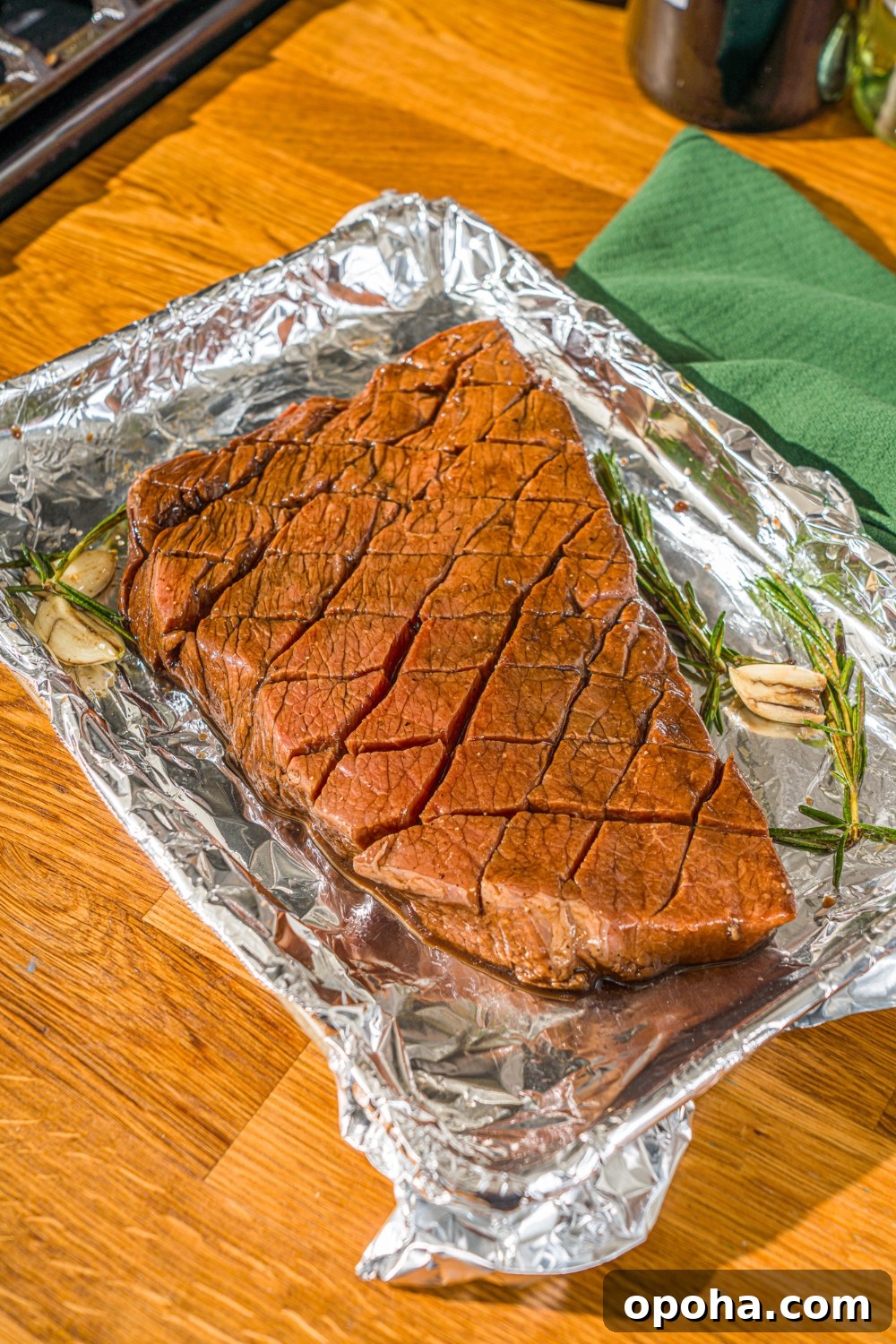 A baking sheet with marinated London broil with garlic and rosemary.