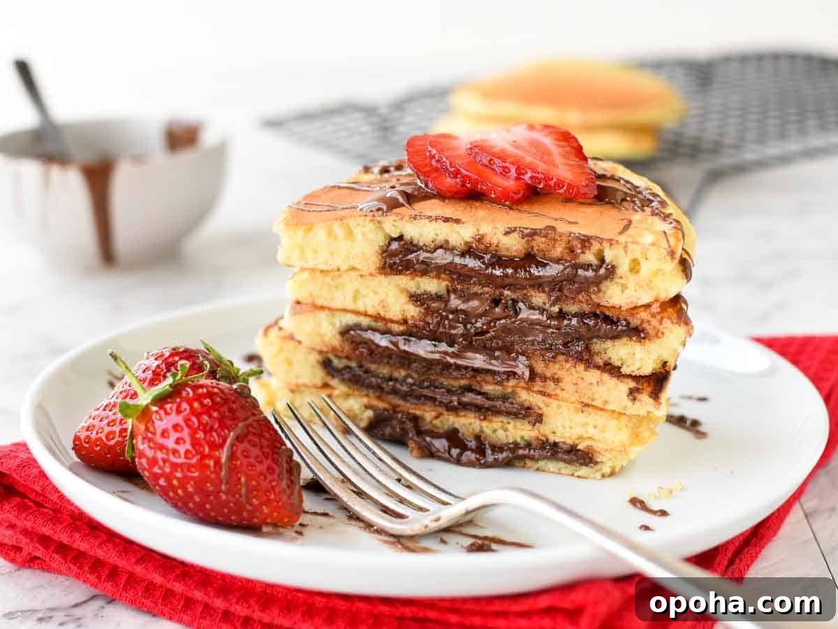 Fluffy Nutella-Stuffed Pancakes 7 Stack of halves pancakes with melted chocolate inside.