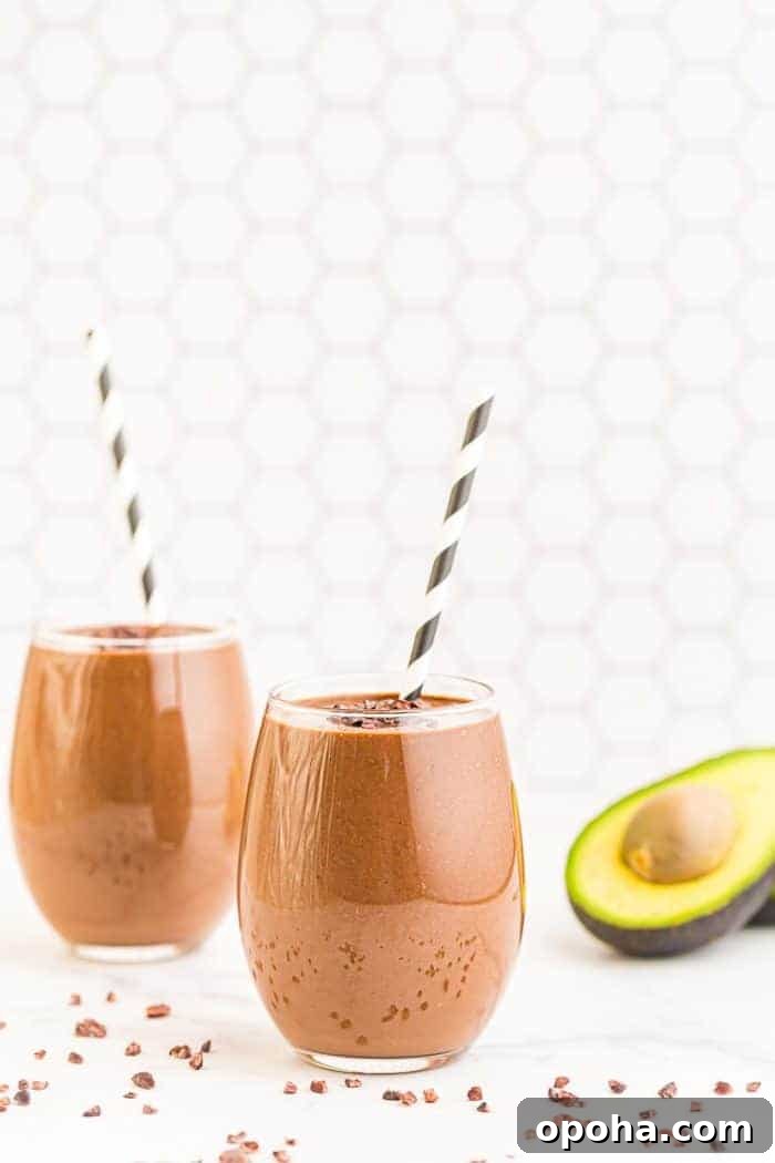 Keto Chocolate Smoothie or Creamy Pudding 9 two keto chocolate smoothies with straws next to an avocado half